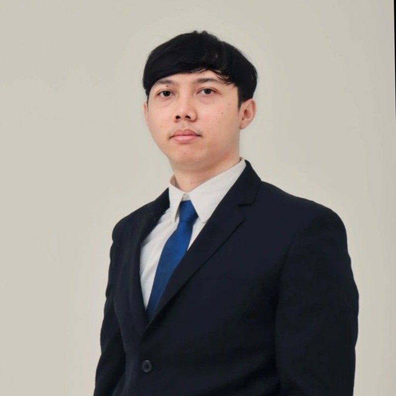 Bima Adityo Kurniawan wearing a dark suit and blue tie